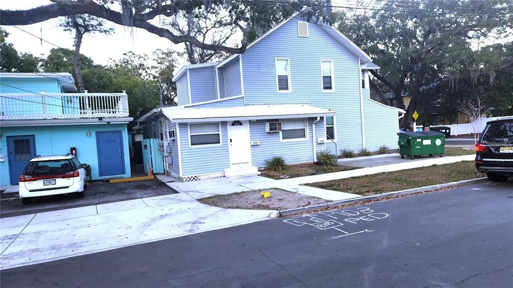 A light blue two-story house with a white door and a green dumpster nearby — 614 OAK AVENUE, CLEARWATER, FL