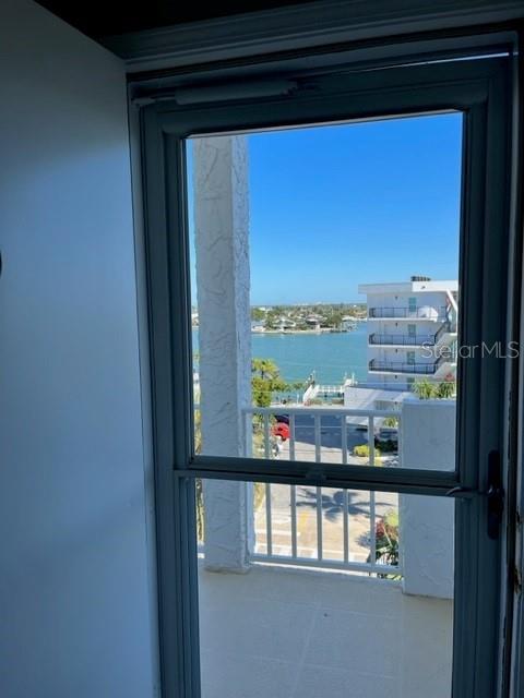 A view of a waterway and neighboring buildings seen through a glass door — 285 107TH AVENUE UNIT 606, TREASURE ISLAND, FL