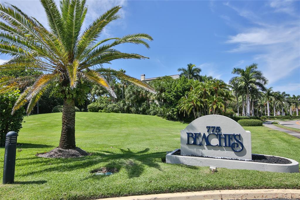 A sign for a property named Beaches sits on a grassy lawn with palm trees — 775 LONGBOAT CLUB ROAD UNIT 904, LONGBOAT KEY, FL
