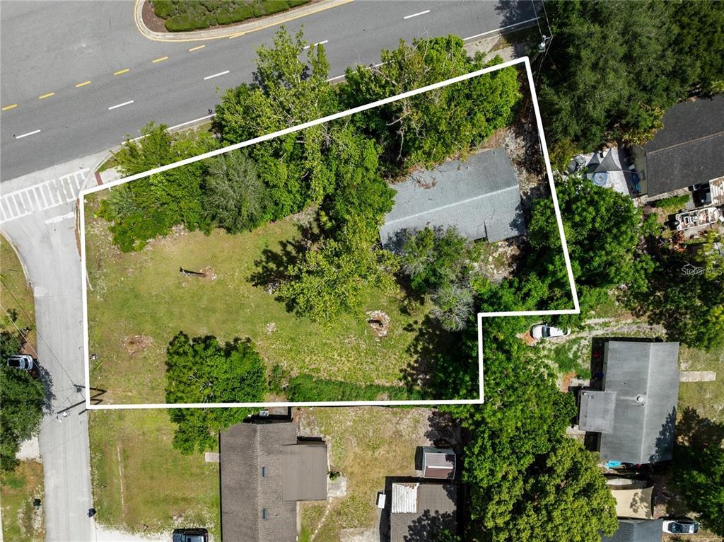An aerial view shows a residential lot with a house, trees, and surrounding streets — 3711 N RONALD REAGAN BOULEVARD, LONGWOOD, FL