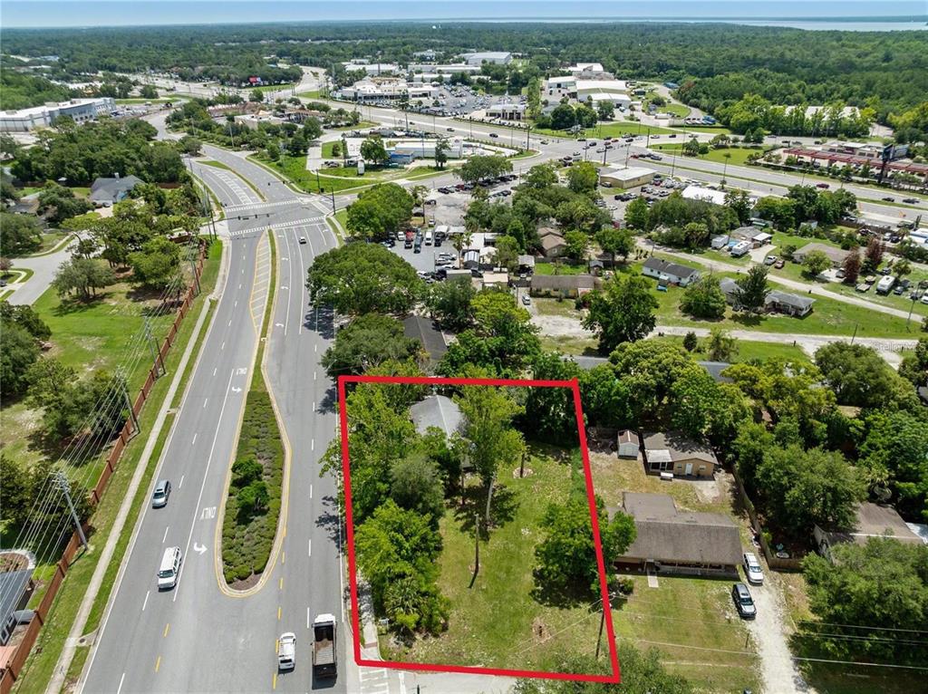 An aerial view shows a rectangular lot with a house and trees beside a road — 3711 N RONALD REAGAN BOULEVARD, LONGWOOD, FL