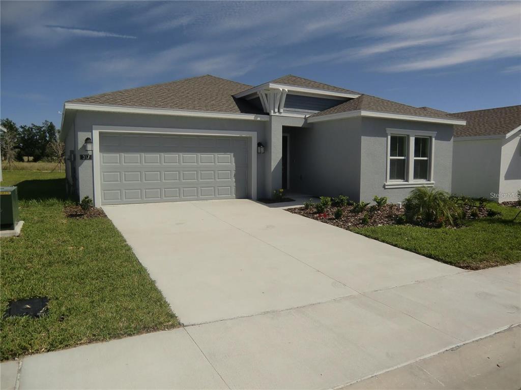 A single-story house with a gray stucco exterior, a two-car garage, and a concrete driveway — 317 LOCH COURT, DAVENPORT, FL