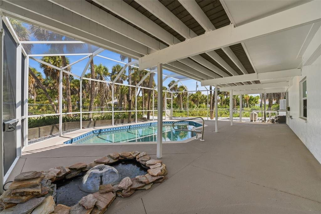 A light blue elevated house with a paved driveway and palm trees in the yard — 6000 N BEACH ROAD, ENGLEWOOD, FL