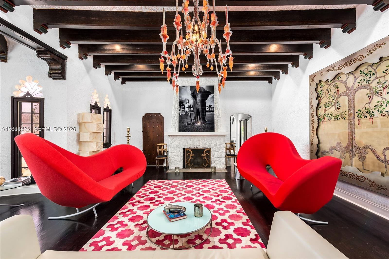 A living room features two red sculptural sofas, a patterned rug, and a large chandelier — 1036 NE 89th St, Miami FL 33138, MIAMI, FL
