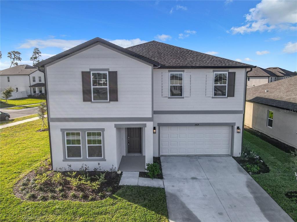 A two-story house with white siding, a gray roof, and a two-car garage — 1469 ARBOR HILL DRIVE, DELTONA, FL