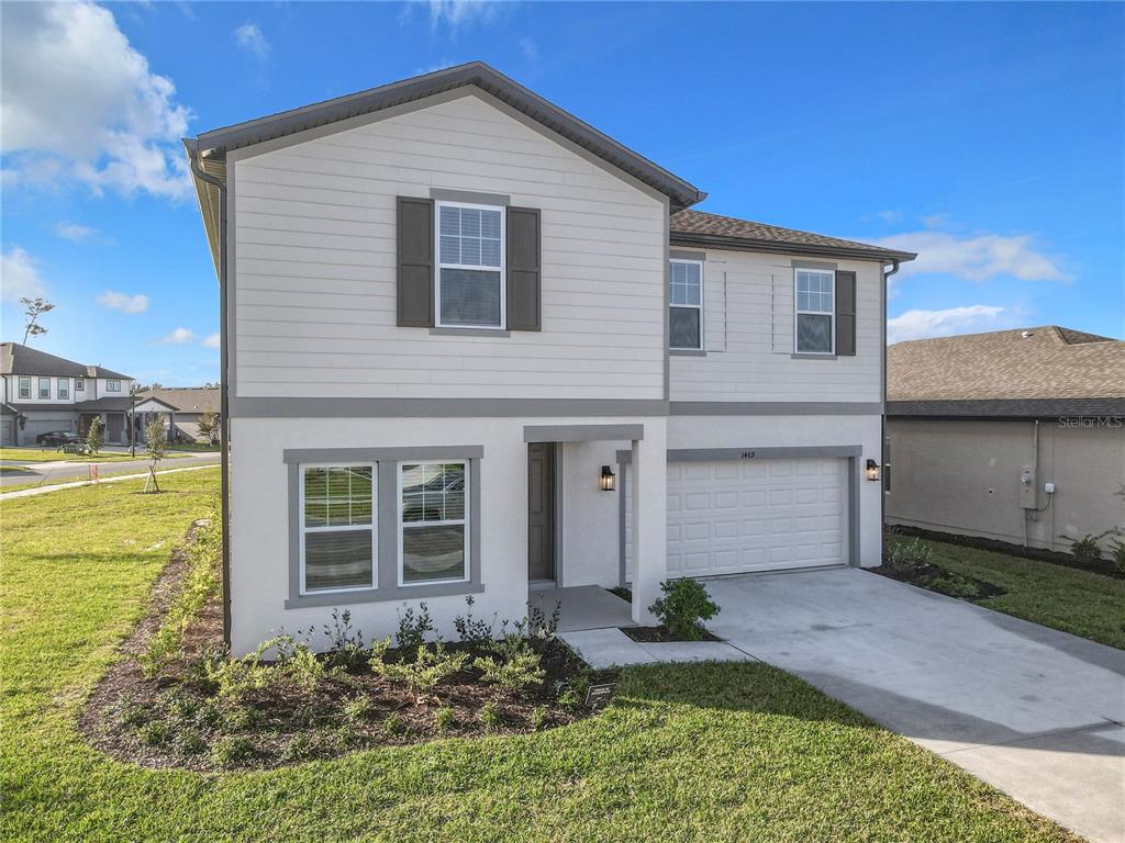 A two-story house with white siding, a gray-trimmed exterior, and an attached two-car garage — 1469 ARBOR HILL DRIVE, DELTONA, FL