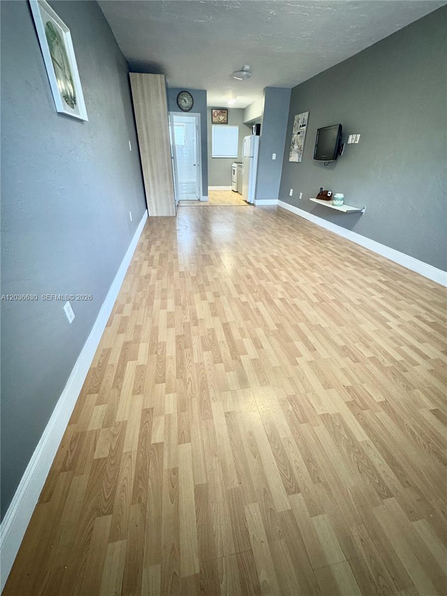 This room features light wood-look flooring, gray walls, and a small floating shelf — 1611 West Ave # 10, Miami Beach FL 33139, MIAMI BEACH, FL