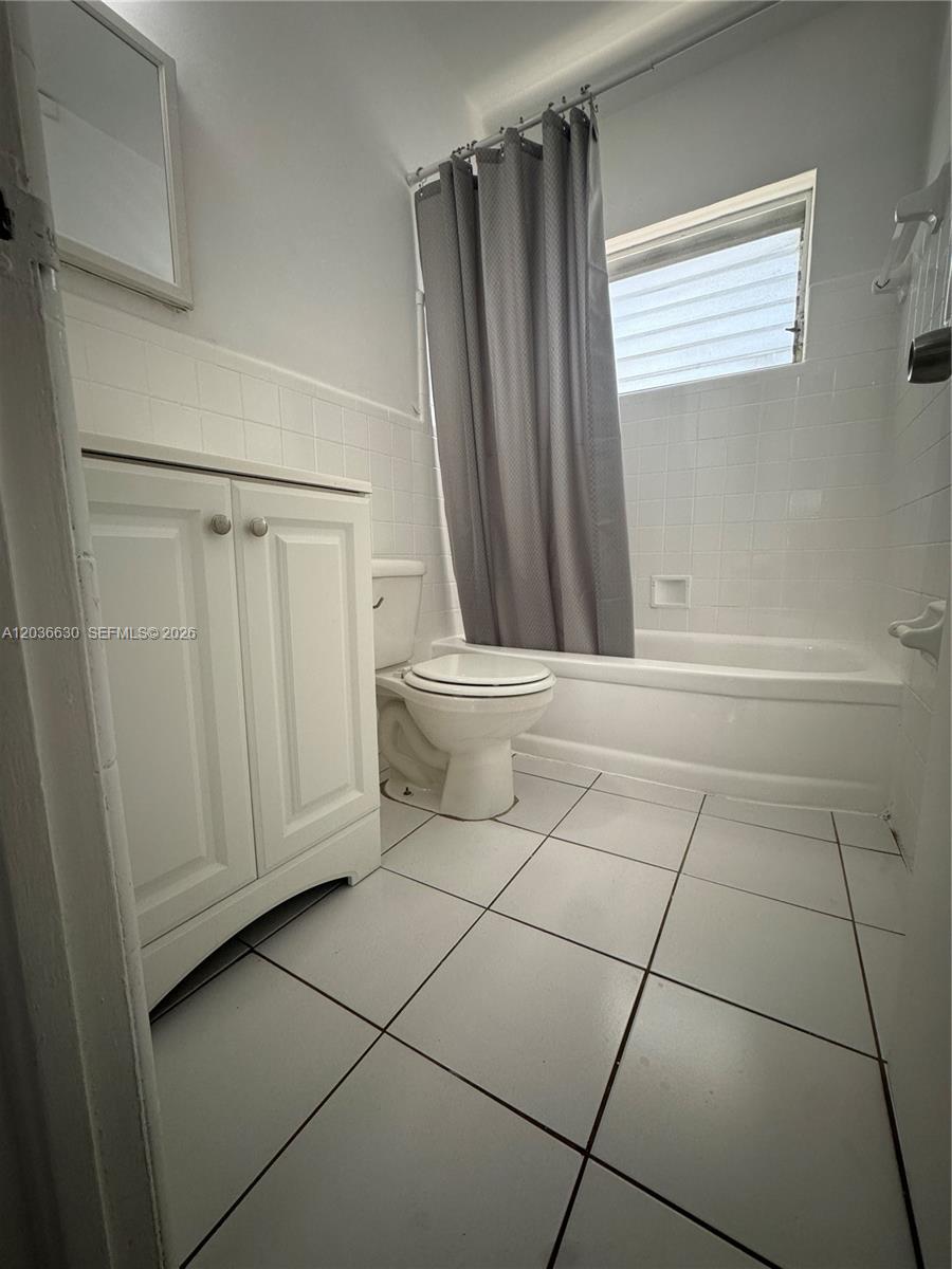 A small bathroom features a white vanity, a toilet, and a shower-tub combination — 1611 West Ave # 10, Miami Beach FL 33139, MIAMI BEACH, FL
