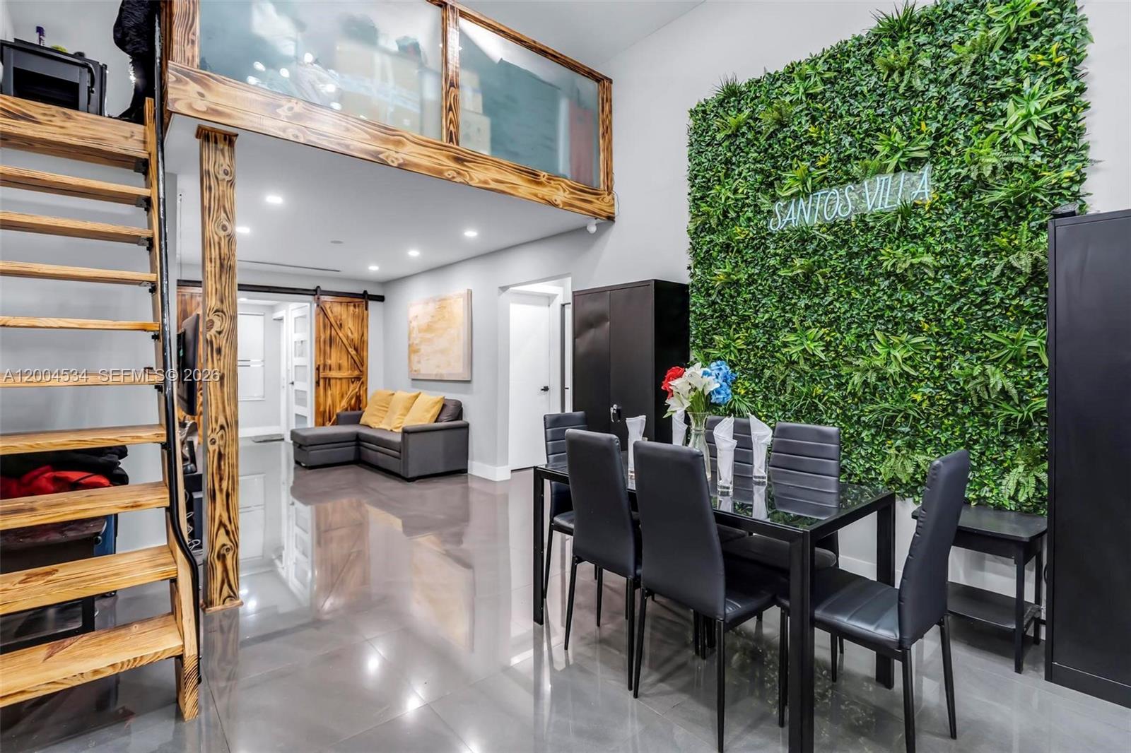A dining area with a green wall and a loft level overlooks a living room — 1741 NW 44th St, Miami FL 33142, MIAMI, FL