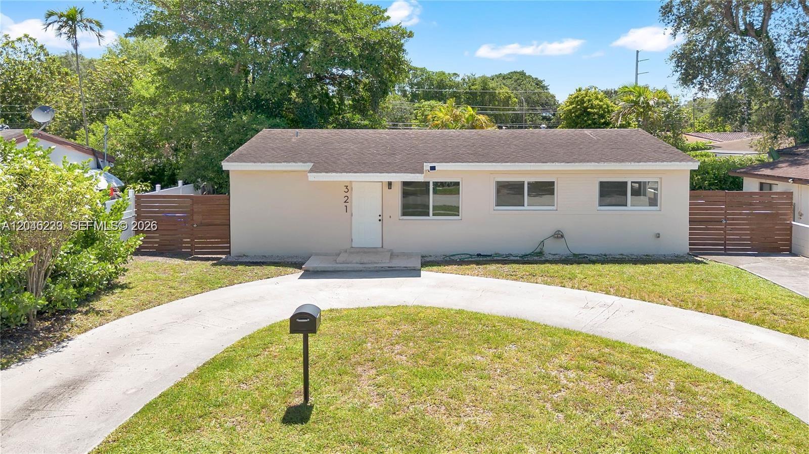 A single-story house with a beige exterior, a white front door, and a curved driveway — 321 NW 56th Ave, Miami FL 33126, MIAMI, FL