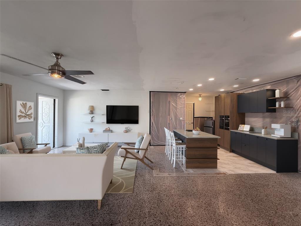 A living room and kitchen area with dark cabinets, a kitchen island, and speckled flooring — 414 86TH AVENUE, ST PETE BEACH, FL