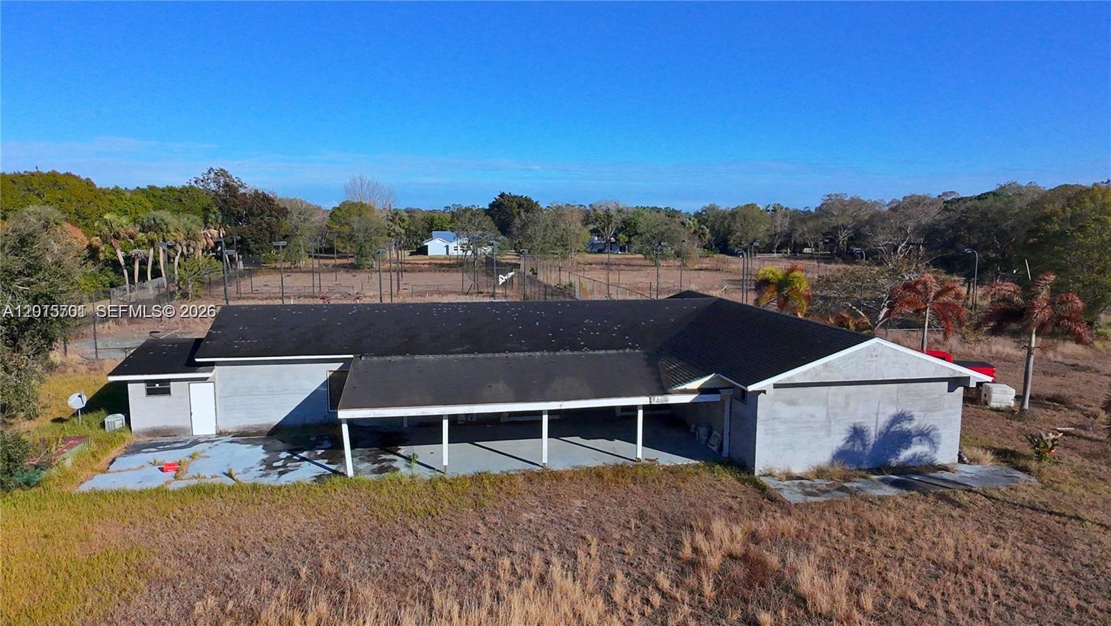 An aerial view shows the rear exterior of a house with a large covered patio — 4291 SW 5th Pl SW, Vero Beach FL 32968, VERO BEACH, FL