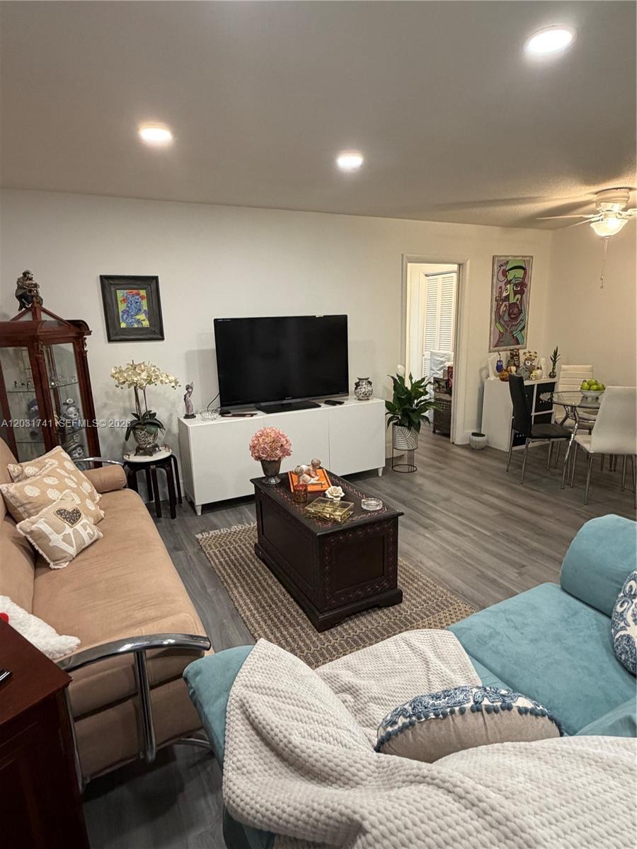 A living room features a beige sofa, a blue sofa, a television, and wood-look flooring — 3500 Harrison # 4, Hollywood FL 33021, HOLLYWOOD, FL