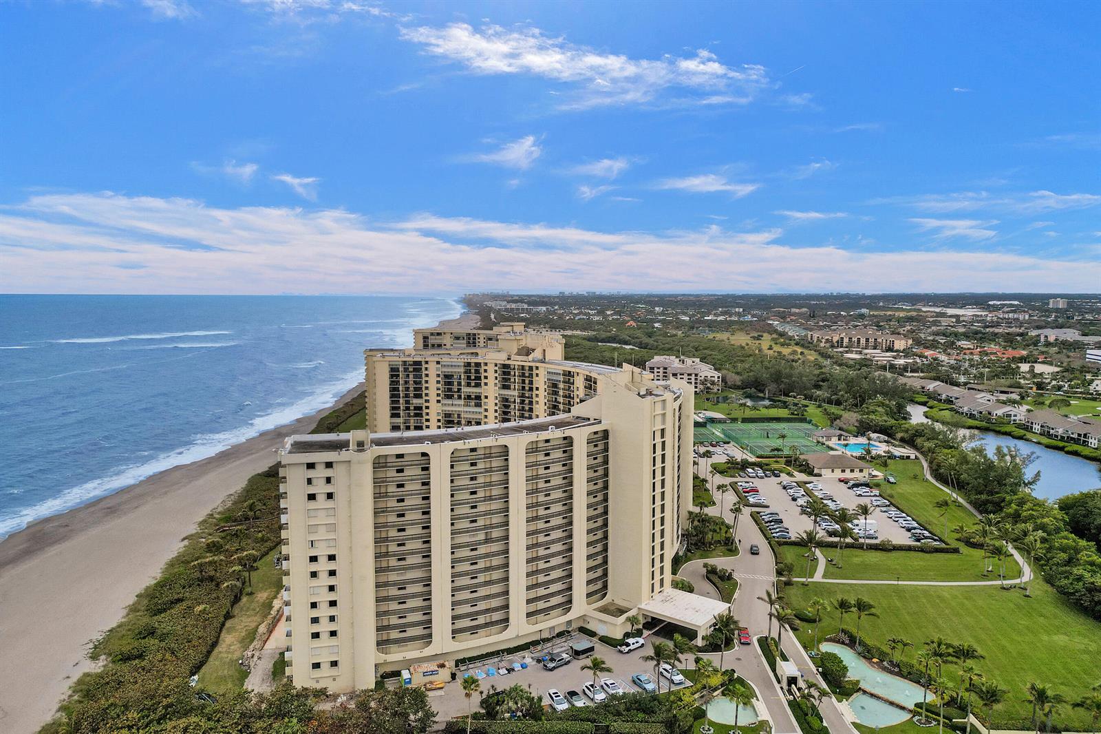 An aerial view of a large, curved beachfront condominium complex with a parking lot and pool — 400 Ocean Trail Way # 308, Jupiter FL 33477, JUPITER, FL