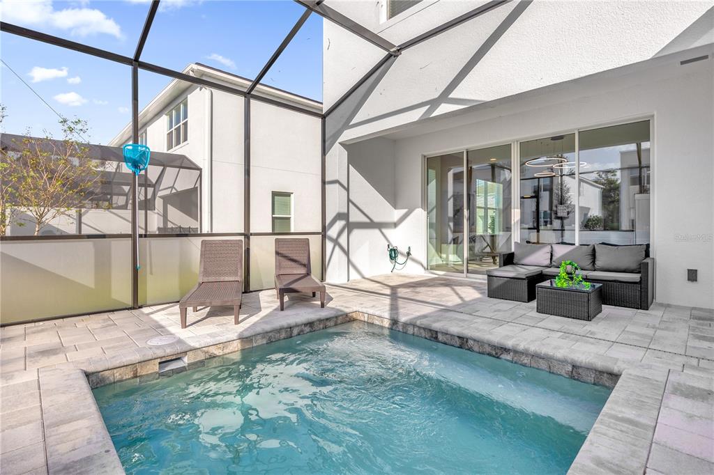 A screened-in patio features a small swimming pool, lounge chairs, and outdoor furniture — 1389 PEACEFUL NATURE WAY, CLERMONT, FL