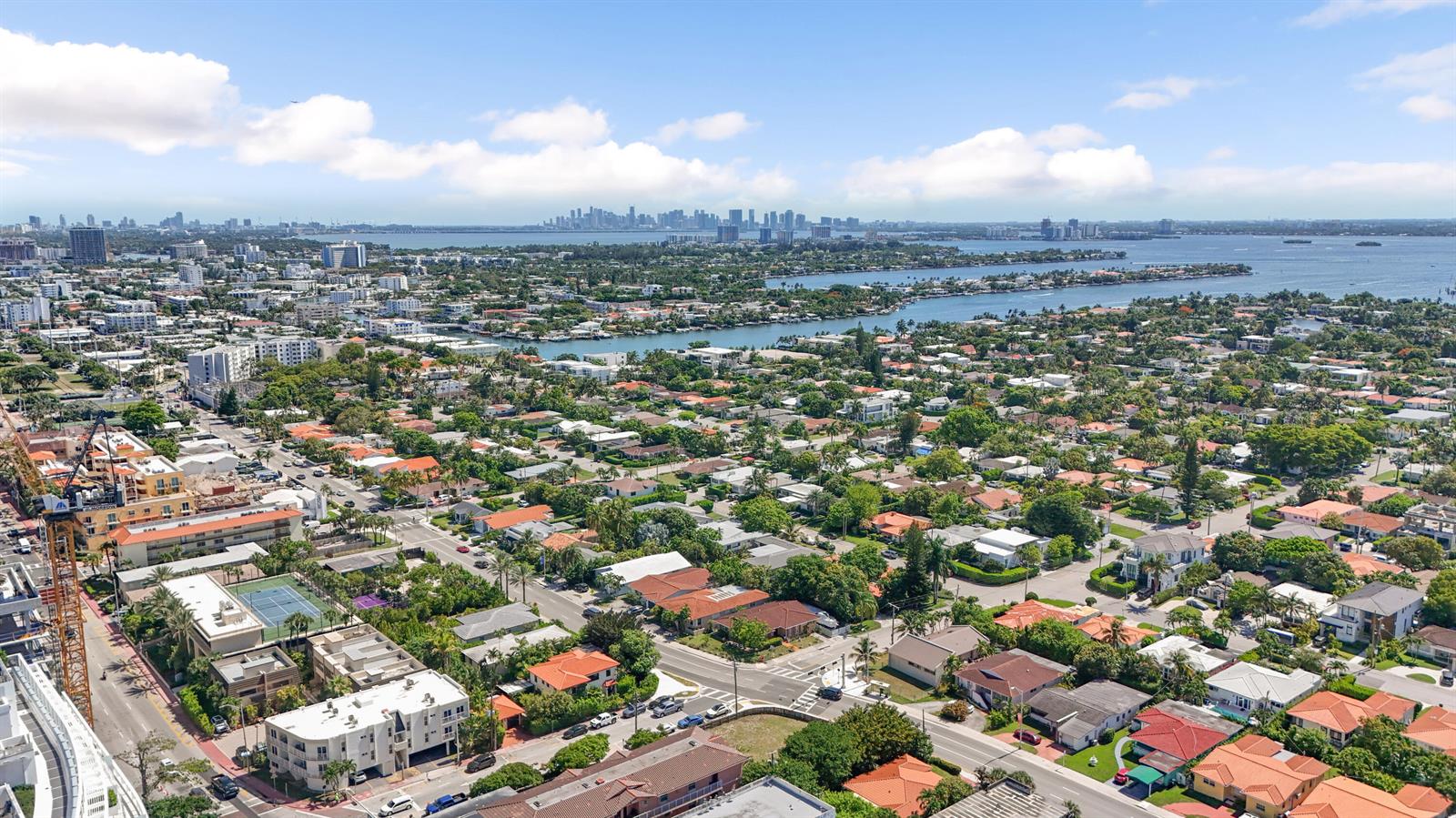 An aerial view shows a residential neighborhood with a waterway and a distant city skyline — 8956 Collins Avenue # 4, Surfside FL 33154, SURFSIDE, FL