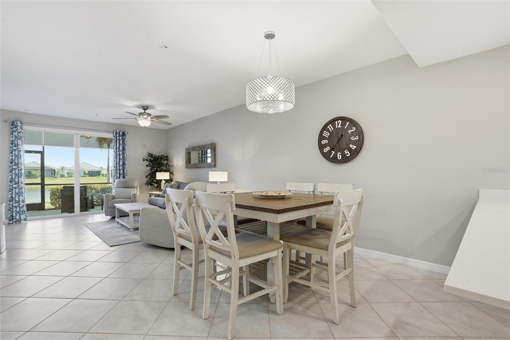A dining area with a wooden table and chairs sits in an open-concept living space — 14204 HERITAGE LANDING BOULEVARD UNIT 712, PUNTA GORDA, FL