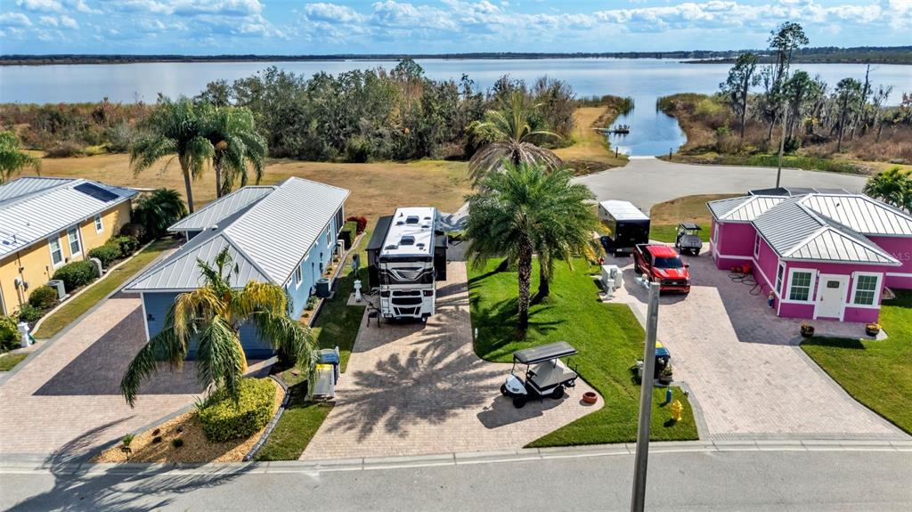 An aerial view shows two houses, an RV, and a golf cart near a lake — 3268 FISH HAWK DRIVE, POLK CITY, FL