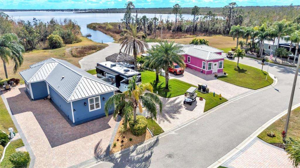An aerial view shows two houses with metal roofs, a parked RV, and palm trees — 3268 FISH HAWK DRIVE, POLK CITY, FL
