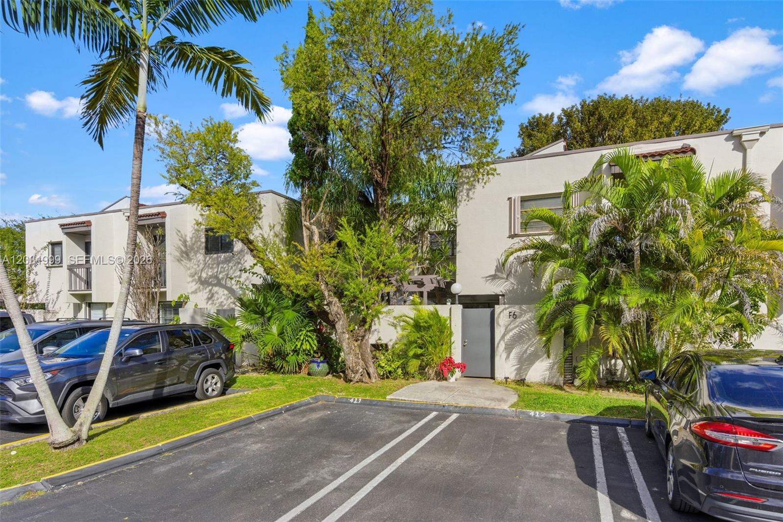 A two-story residential building exterior features a parking lot, palm trees, and a gray door — 4726 SW 67th Ave # F6, Miami FL 33155, MIAMI, FL