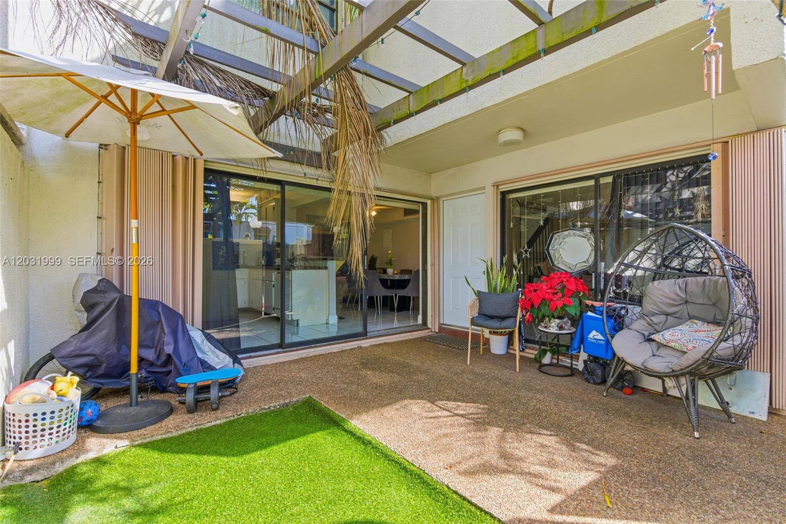 A patio features a pergola, artificial turf, sliding glass doors, and various outdoor furniture — 4726 SW 67th Ave # F6, Miami FL 33155, MIAMI, FL