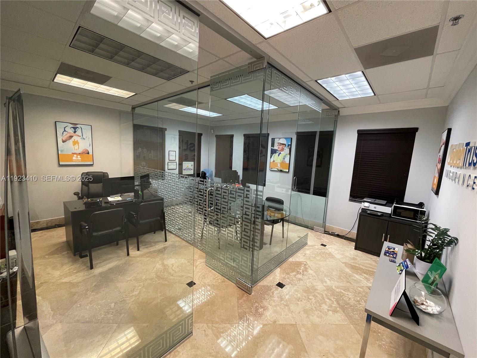 An office space features a glass-enclosed conference room, tiled floors, and professional furniture — 2893 Executive Park Dr # 104, Weston FL 33331, WESTON, FL