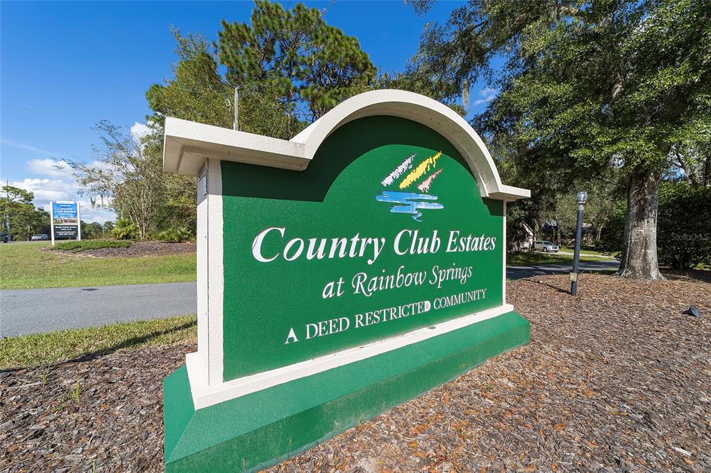 A green sign for Country Club Estates at Rainbow Springs stands in a landscaped area — 19811 SW 95TH STREET, DUNNELLON, FL