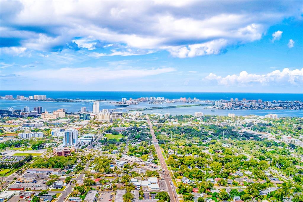 An aerial view shows a coastal city with buildings, a bridge, and a large body of water — 1329 DREW STREET UNIT 6, CLEARWATER, FL