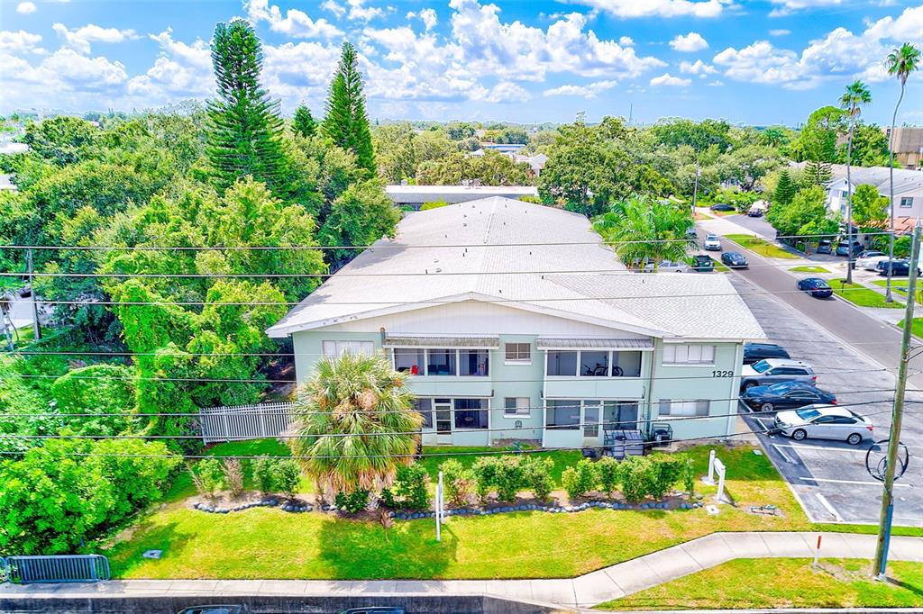An aerial view shows a two-story apartment building with a light green exterior — 1329 DREW STREET UNIT 6, CLEARWATER, FL