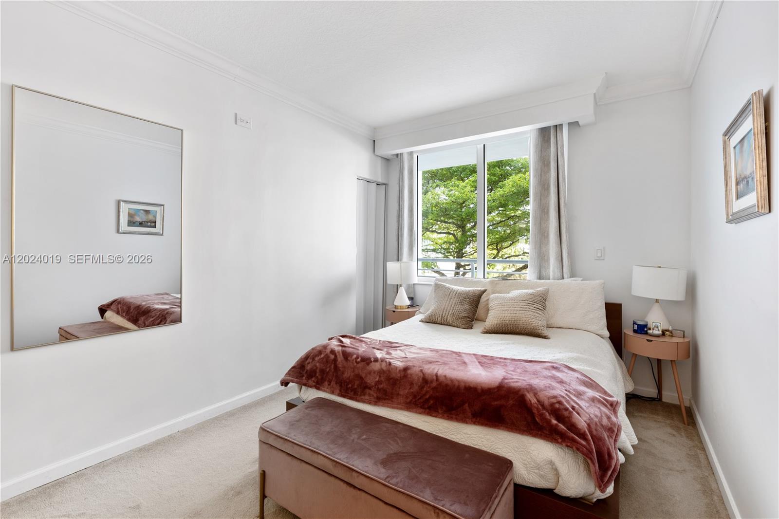 A bedroom features a bed with a maroon throw, a large wall mirror, and windows — 335 S Biscayne Blvd # 802, Miami FL 33131, MIAMI, FL