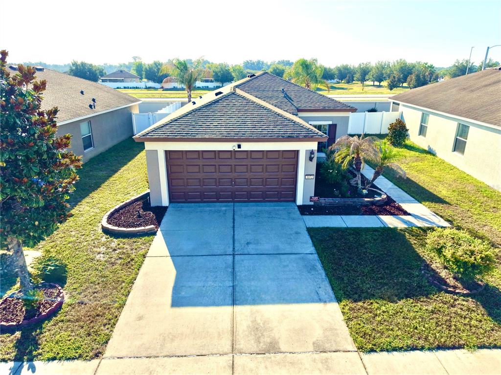 An exterior view of a single-story house with a brown garage door and driveway — 1072 HILL FLOWER DRIVE, BROOKSVILLE, FL