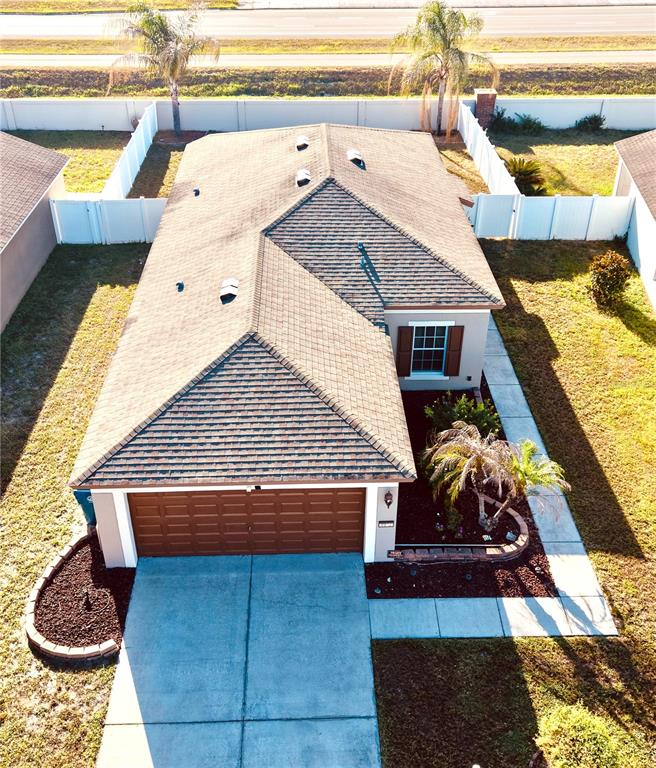 An aerial view of a single-story house with a brown shingled roof and garage — 1072 HILL FLOWER DRIVE, BROOKSVILLE, FL