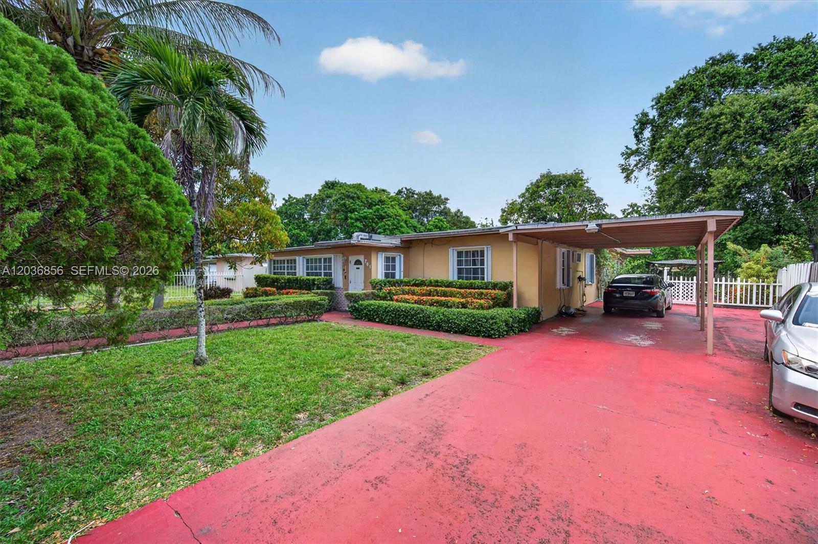 A single-story house with a red driveway, carport, and manicured hedges in the front yard — 761 NE 139th St, North Miami FL 33161, NORTH MIAMI, FL
