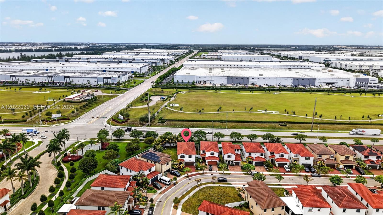 An aerial view shows a residential neighborhood with red-tiled roofs near a large industrial park — 10400 W 35 Way, Hialeah FL 33018, HIALEAH, FL