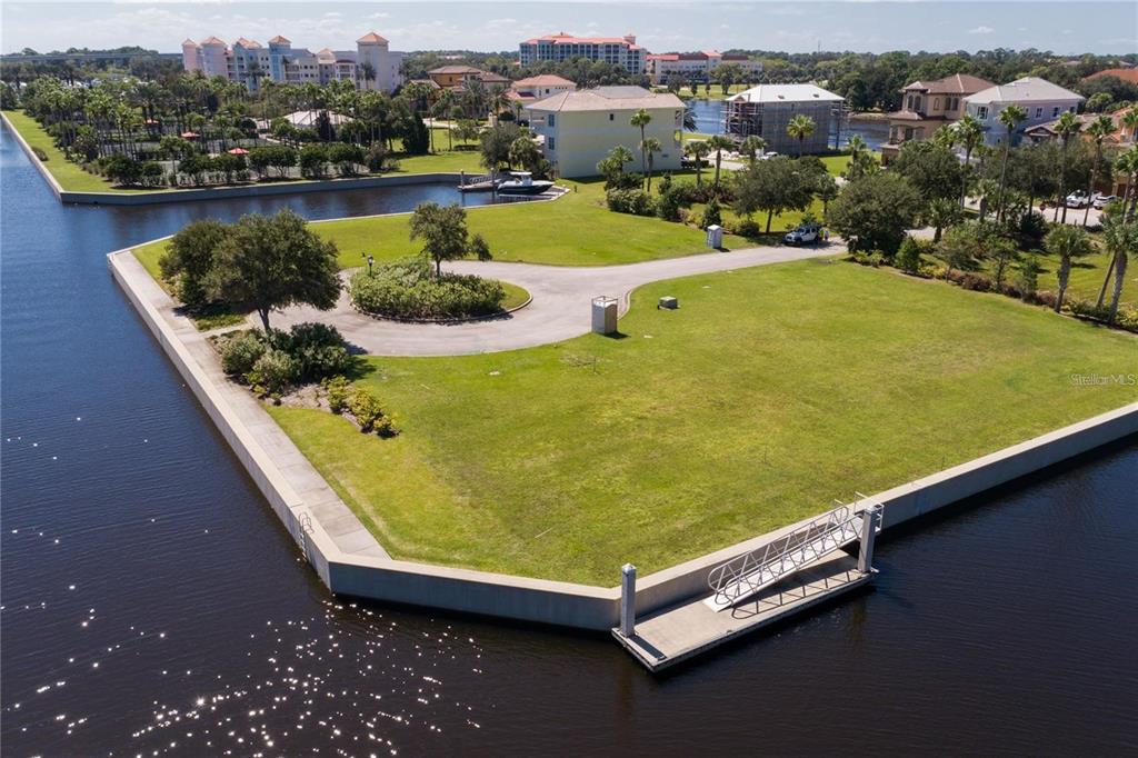 An aerial view shows a vacant waterfront lot with a concrete seawall and boat dock — 10 CUTTER COURT, PALM COAST, FL