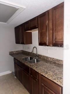 A kitchen features dark wood cabinets, granite countertops, and a stainless steel sink with faucet — 900 LAKE DESTINY ROAD UNIT B, ALTAMONTE SPRINGS, FL