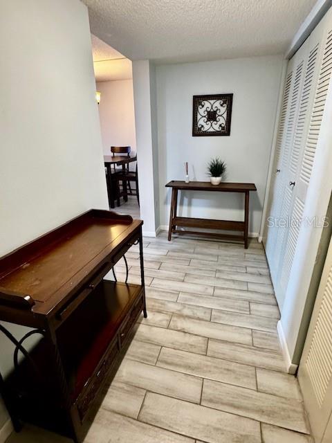 A hallway features light-colored tile flooring, a dark wood console table, and a wall-mounted table — 3006 CARING WAY UNIT 301, PORT CHARLOTTE, FL