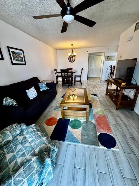 A living room features a dark sofa, a patterned area rug, and a wooden coffee table — 3006 CARING WAY UNIT 301, PORT CHARLOTTE, FL