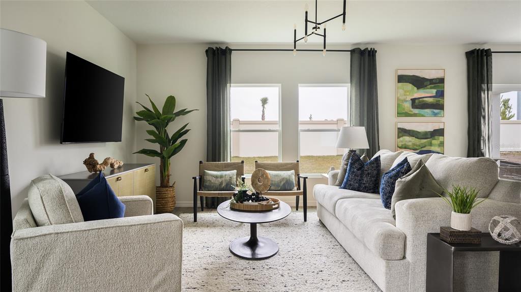 A living room features a sofa, two armchairs, a coffee table, and a wall-mounted television — 9098 BELLEVIEW FOREST PASS, DADE CITY, FL