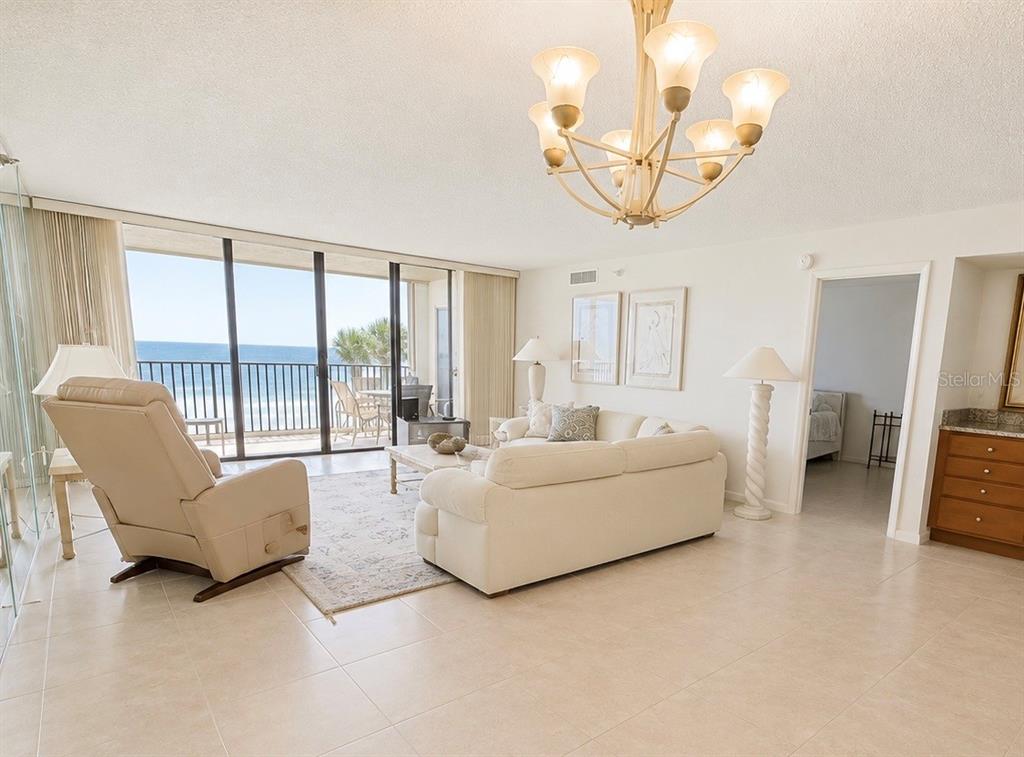 A bright kitchen features white cabinets, granite countertops, and a view of the ocean — 2675 GULF OF MEXICO DRIVE UNIT 203, LONGBOAT KEY, FL