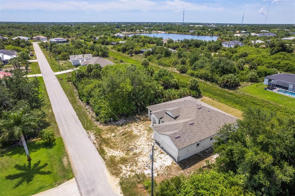 An aerial view shows a single-story house with a gray roof next to a road — 13298 HIGH SPRINGS AVENUE, PORT CHARLOTTE, FL