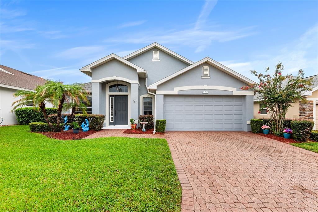 A gray single-story house with a brick paver driveway and a front-facing two-car garage — 4134 BEDFORD AVENUE, WINTER HAVEN, FL