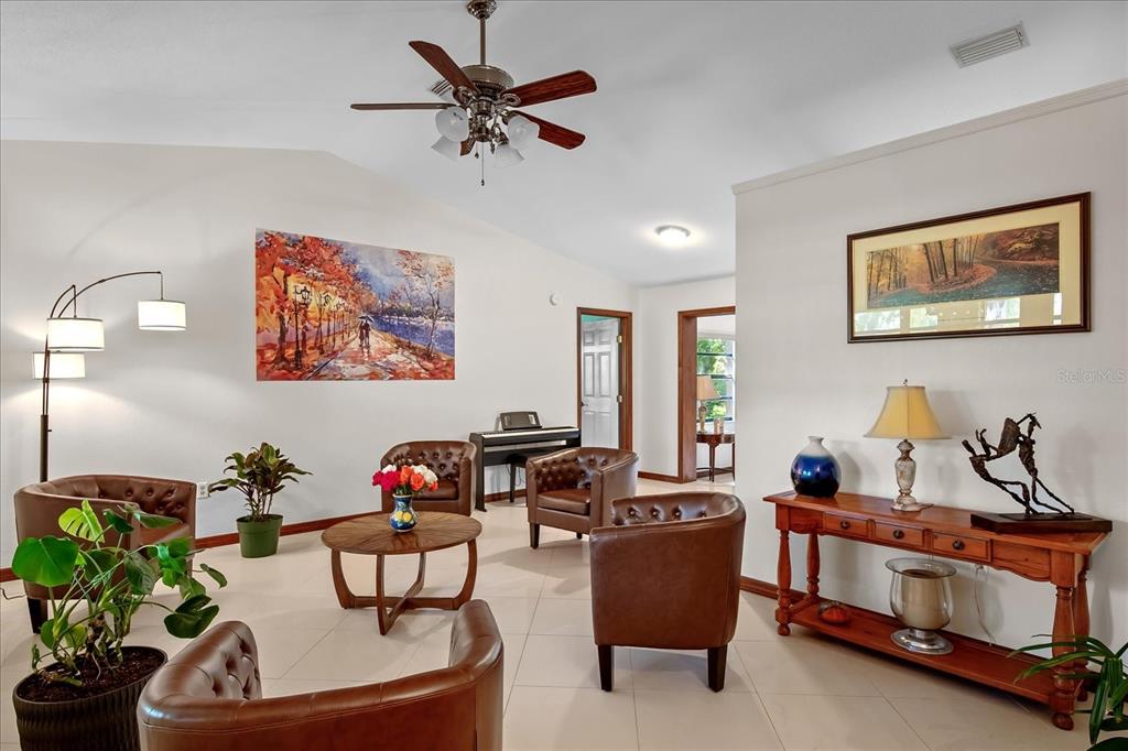 A living room features brown leather armchairs, a wooden coffee table, and a console table — 1273 SCRUB JAY TRAIL, FROSTPROOF, FL