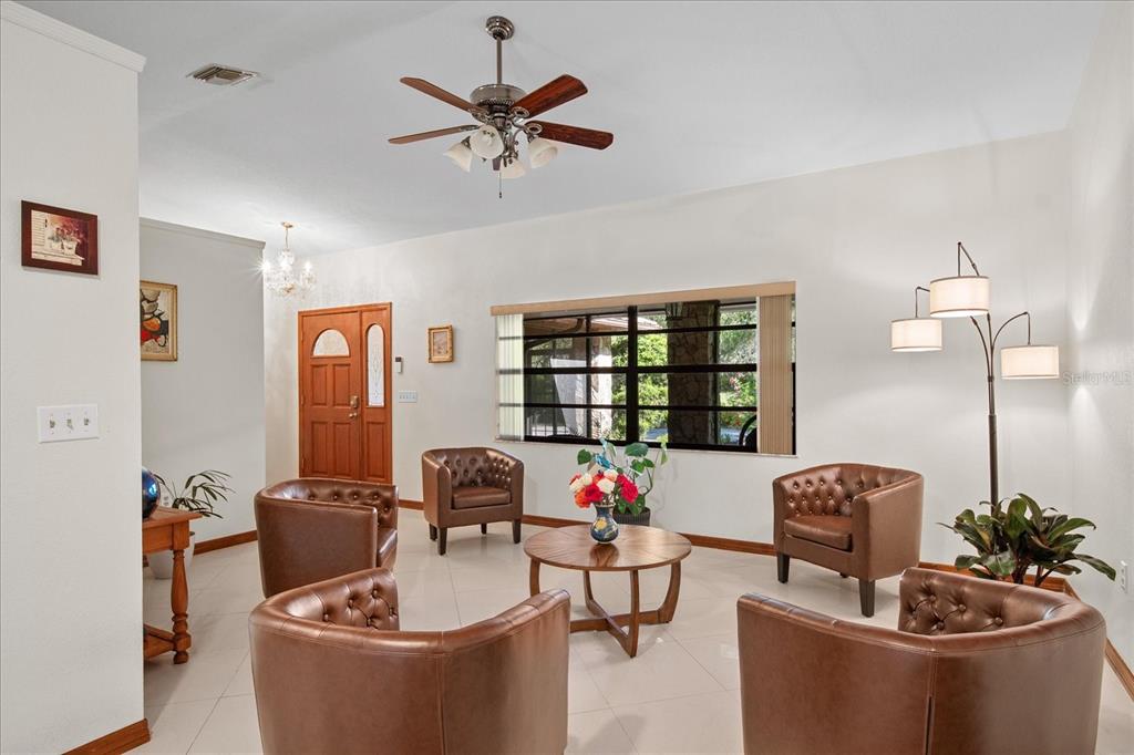 A living room features four brown leather armchairs arranged around a round wooden coffee table — 1273 SCRUB JAY TRAIL, FROSTPROOF, FL