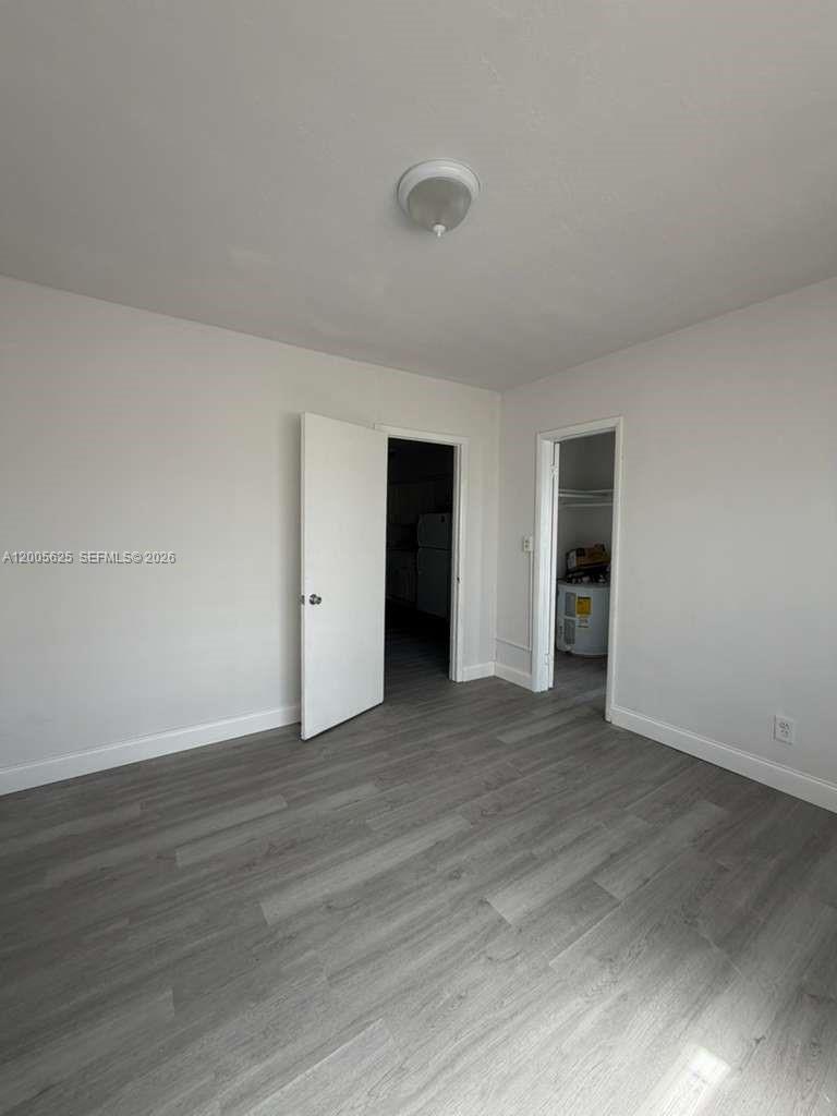 A room with light-colored walls, gray wood-look flooring, and two open doorways — 1628 SW 7th St # 9, Miami FL 33135, MIAMI, FL