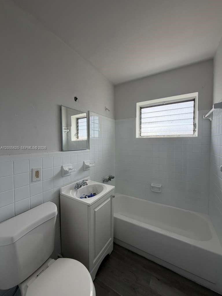A small bathroom features a white pedestal sink, a toilet, and a tiled bathtub — 1628 SW 7th St # 9, Miami FL 33135, MIAMI, FL