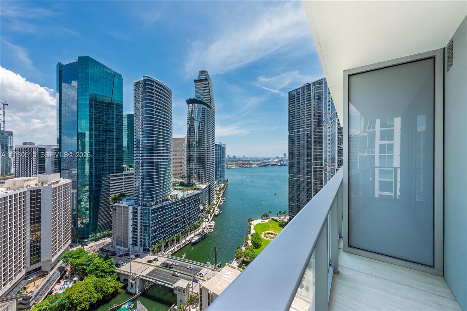 A high-rise balcony overlooks a city skyline, a river, and a bridge — 77 SE 5th Street # 3204, Miami FL 33131, MIAMI, FL