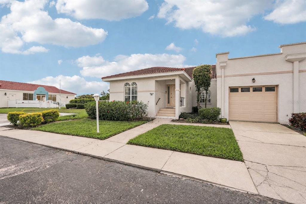 A single-story house with a tan stucco exterior, a tile roof, and an attached garage — 4808 61ST AVENUE TERRACE W, BRADENTON, FL
