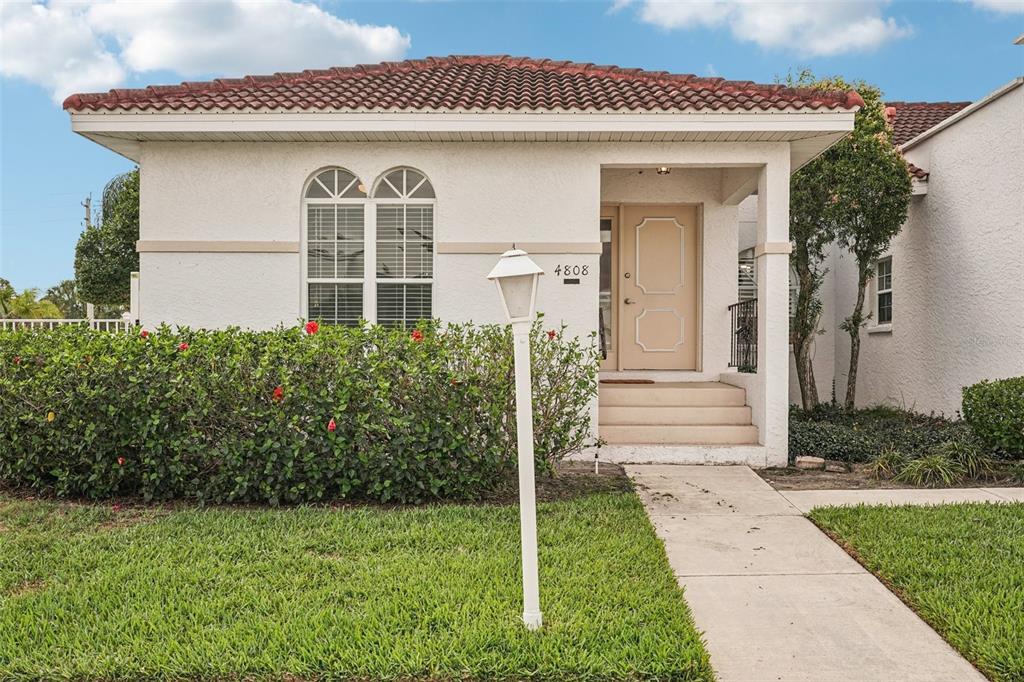 A single-story house with a red tile roof, white stucco exterior, and a front walkway — 4808 61ST AVENUE TERRACE W, BRADENTON, FL