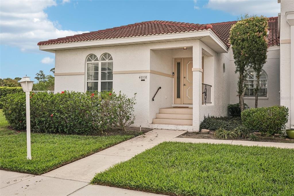 A single-story house with a white stucco exterior, a tiled roof, and a front entryway — 4808 61ST AVENUE TERRACE W, BRADENTON, FL